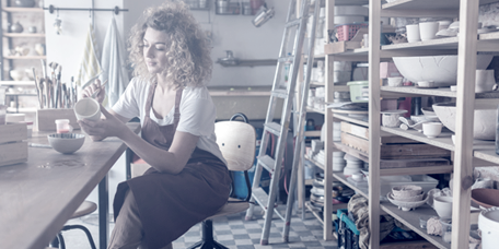 Craftsperson working on a pottery in her retail workshop