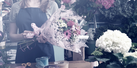 Fiorista prepara un bouquet di fiori primaverili nel suo negozio