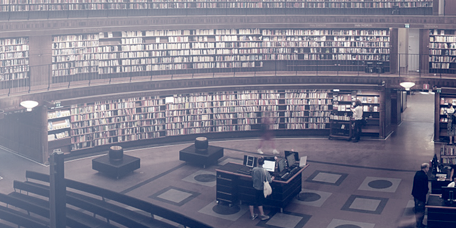 Many books on the shelves and reading space in a library