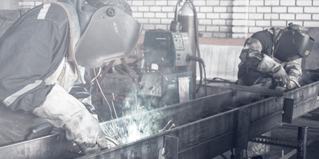 Operators cutting metal according to the production planning of the CAPM software