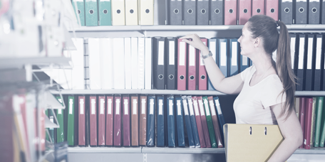 A woman examining various binders for sale in a stationery shop