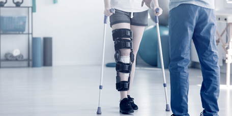 Orthopädietechniker, der einen verletzten Patienten mit Krücken begleitet