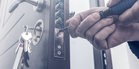 Locksmith installing a secure lock on a door
